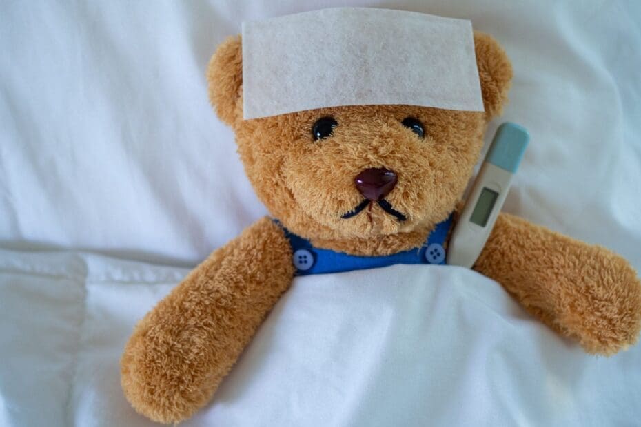 Brown teddy bear with fever-reducing sheet and body temperature monitor. Used to show down with the sickness